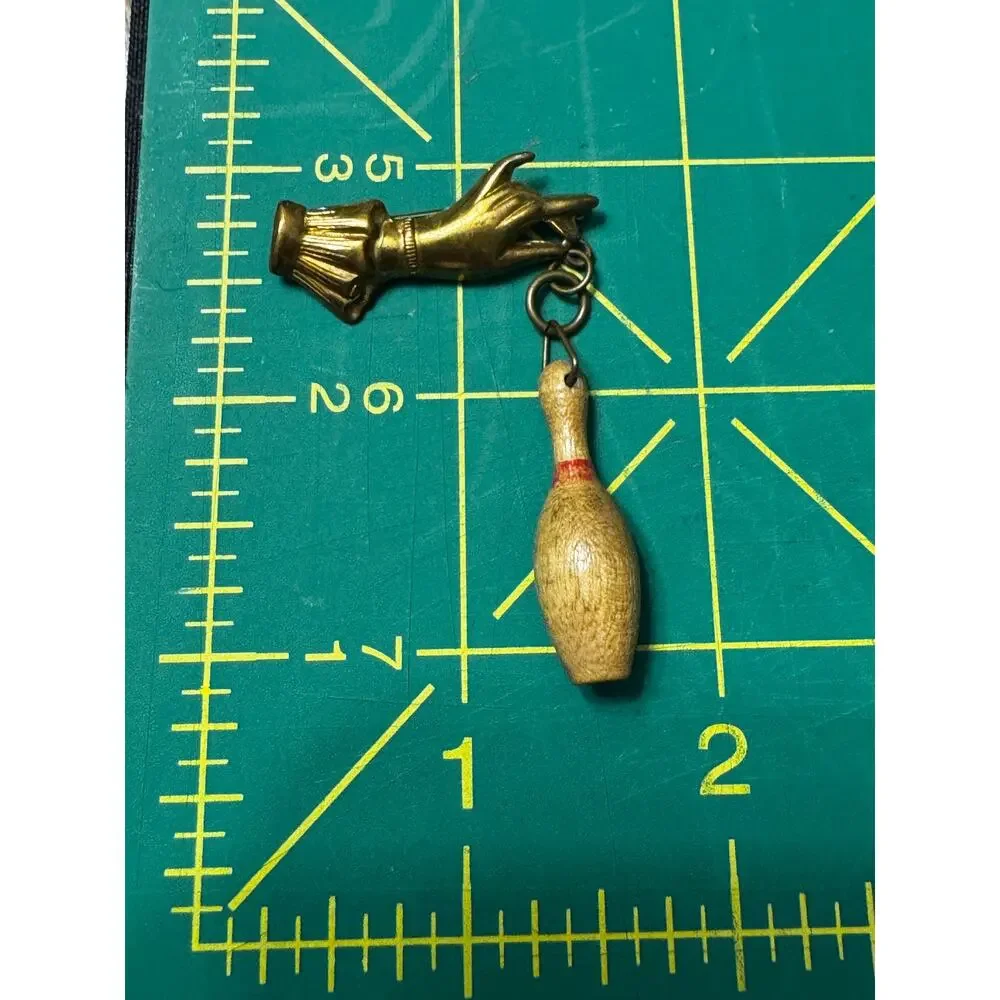 Vintage 50's brass hand with dangling miniature bowling pin brooch